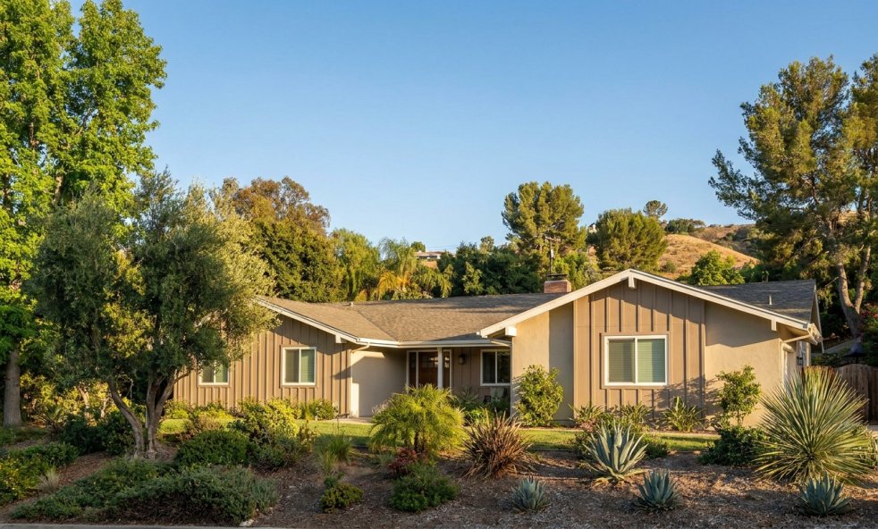 Freshly painted Woodland Hills home with landscaped front yard and trees